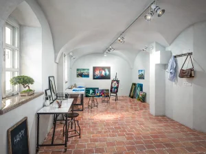 Visualisierung Nonntal, Salzburg, Atelier im Kellerbereich mit Bildern, Arbeitstischen, Bonsai auf der Fensterbank. Boden aus Terracotta.
