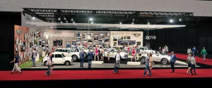 Auf der Vienna Autoshow 2019 sind mehrere MINI Fahrzeuge, Schaufensterpuppen und eine Zeitleiste mit den Jahren 1959 bis 2019 zu sehen. An den Wänden hängen das Zeichen #60yearsofMINI und Bilder aus der Geschichte von MINI.