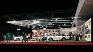 Auf der Vienna Autoshow 2019 sind mehrere MINI Fahrzeuge, Schaufensterpuppen und eine Zeitleiste mit den Jahren 1959 bis 2019 zu sehen. An den Wänden hängen das Zeichen #60yearsofMINI und Bilder aus der Geschichte von MINI.