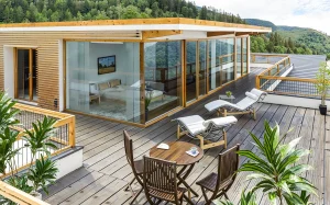 Seevilla Freiberg, Zell am See, Eigner-Loft Terrasse mit zwei Sonnenliegen und einem Kaffee-Holztisch mit 3 Sesseln.