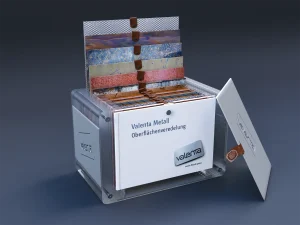 Blechmuster Box aus Acrylglas mit einem magnetischen Verschluss aus Leder, Box ist offen. In der Box sind mehrere Blechmuster und ein Folder. Ein paar Blechmuster sind aus der Box herausgezogen, stehen aber noch in den Einschubspalten.