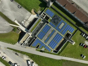 Photovoltaik Anlage auf einem flachen Gebäude, Besucherzentrum in der Gedenkstätte Mauthausen, umgeben von Grasflächen, Top Ansicht.